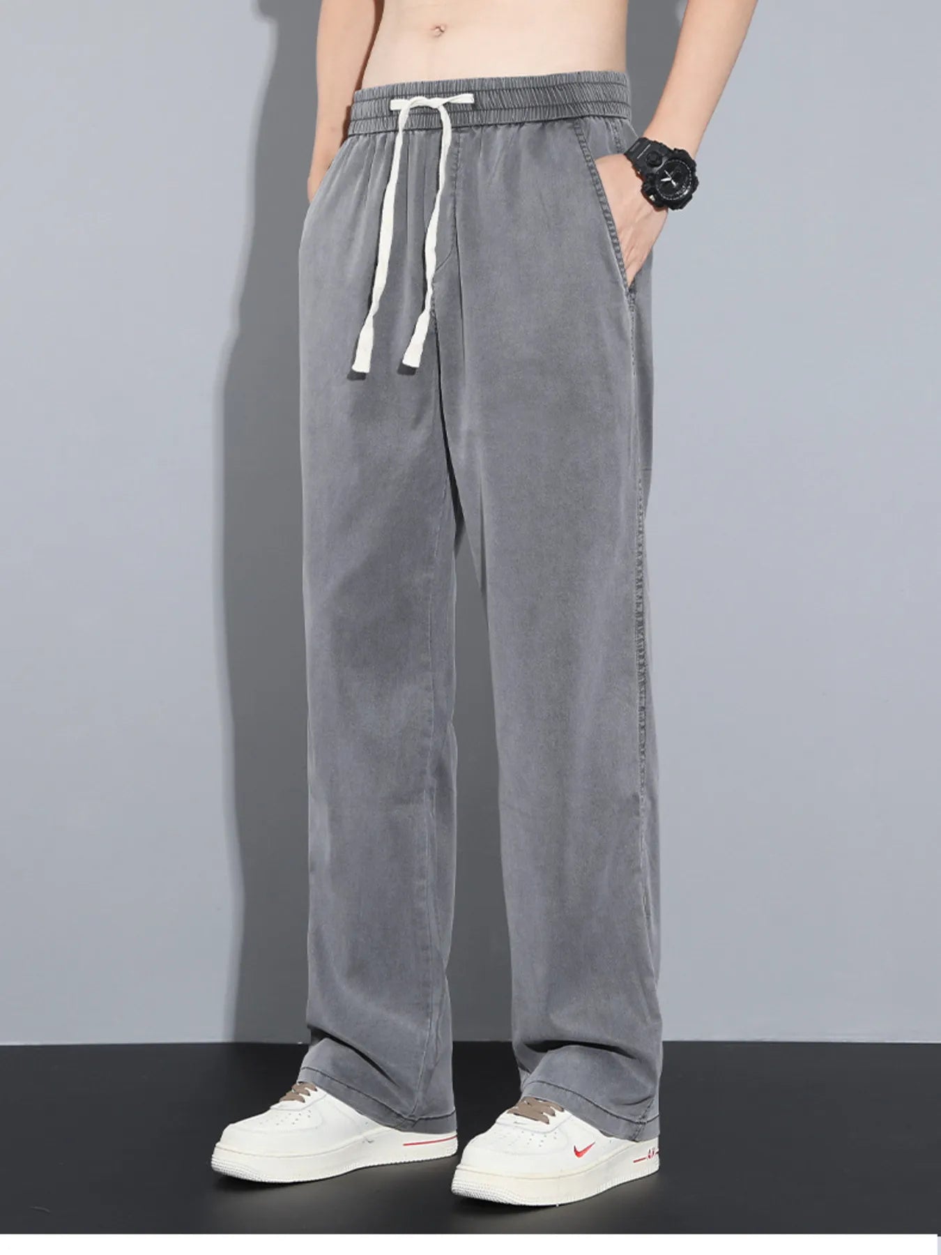 Men's grey casual pants with wide legs and a drawstring waist.