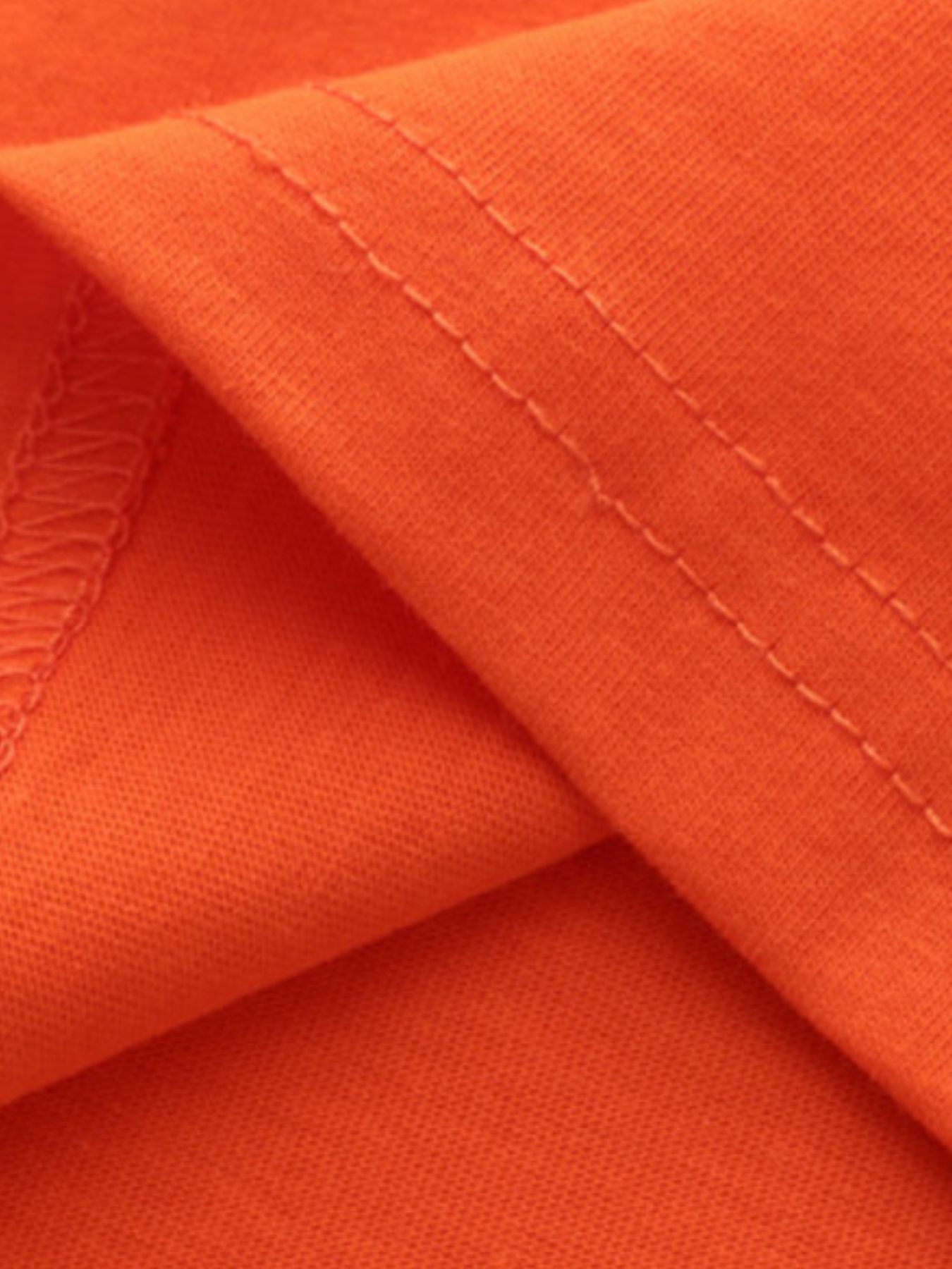 Close view of the double stitched fabric detail on the orange red children's t-shirt