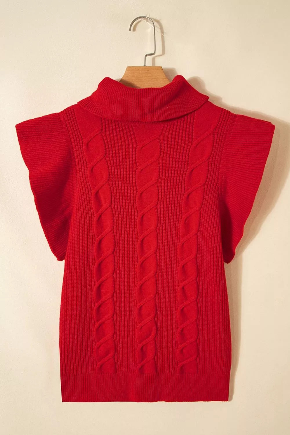 Hanging front view of a red cable knit turtleneck sweater with ruffled short sleeves