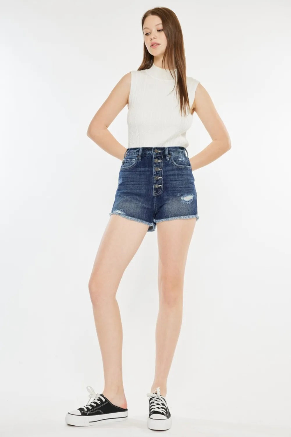 Women's washed denim shorts with a button fly, raw hems, and pockets.