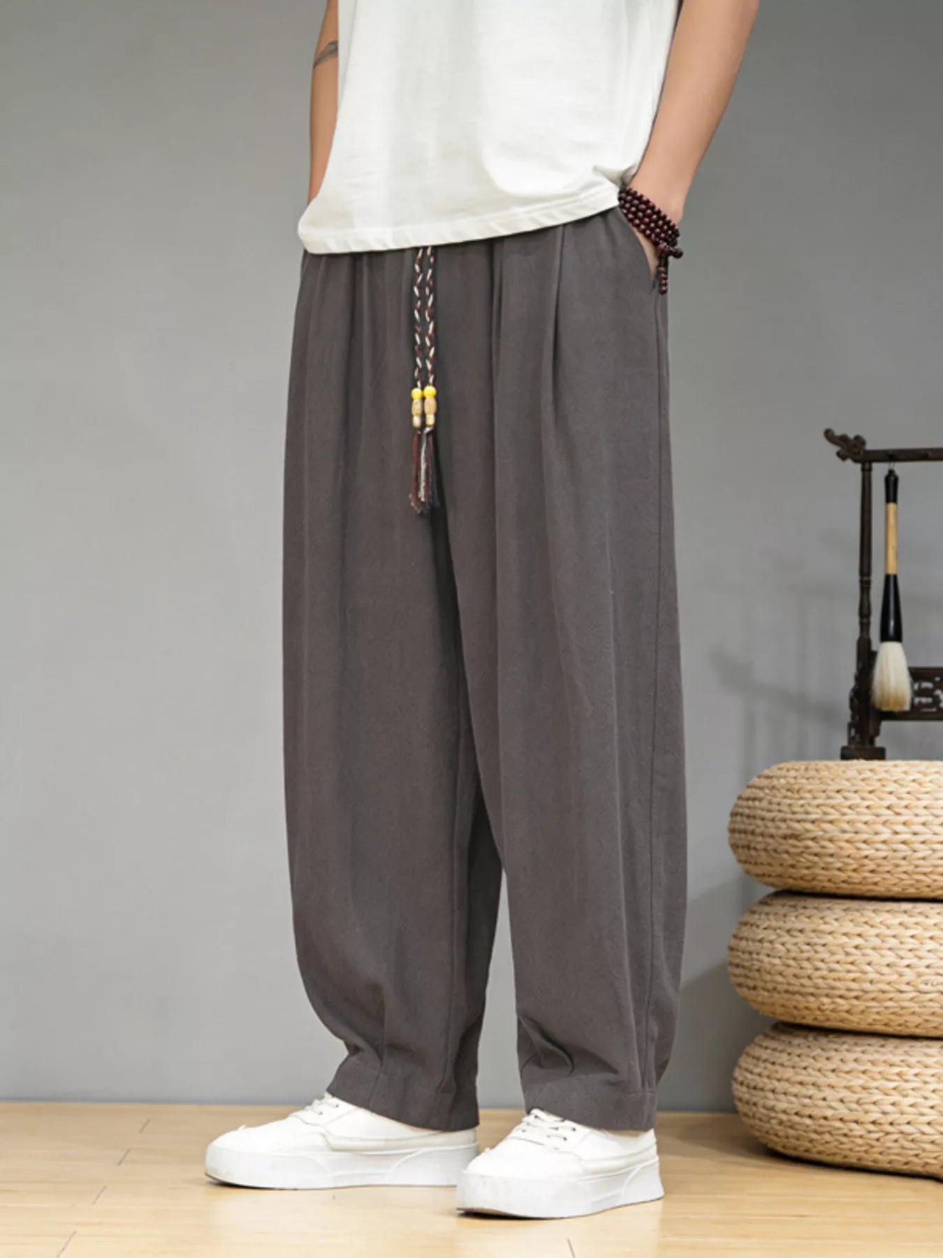 Men's loose fit casual pants with a drawstring waist and pockets.