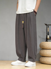 Men's loose fit casual pants with a drawstring waist and pockets.