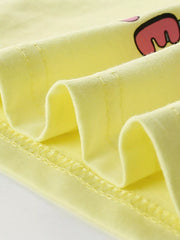 Close view of the light yellow children's tee hem showing soft folded fabric and fine stitching