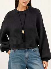 Close on-model front view of a black oversized chunky knit sweater with ribbed hem