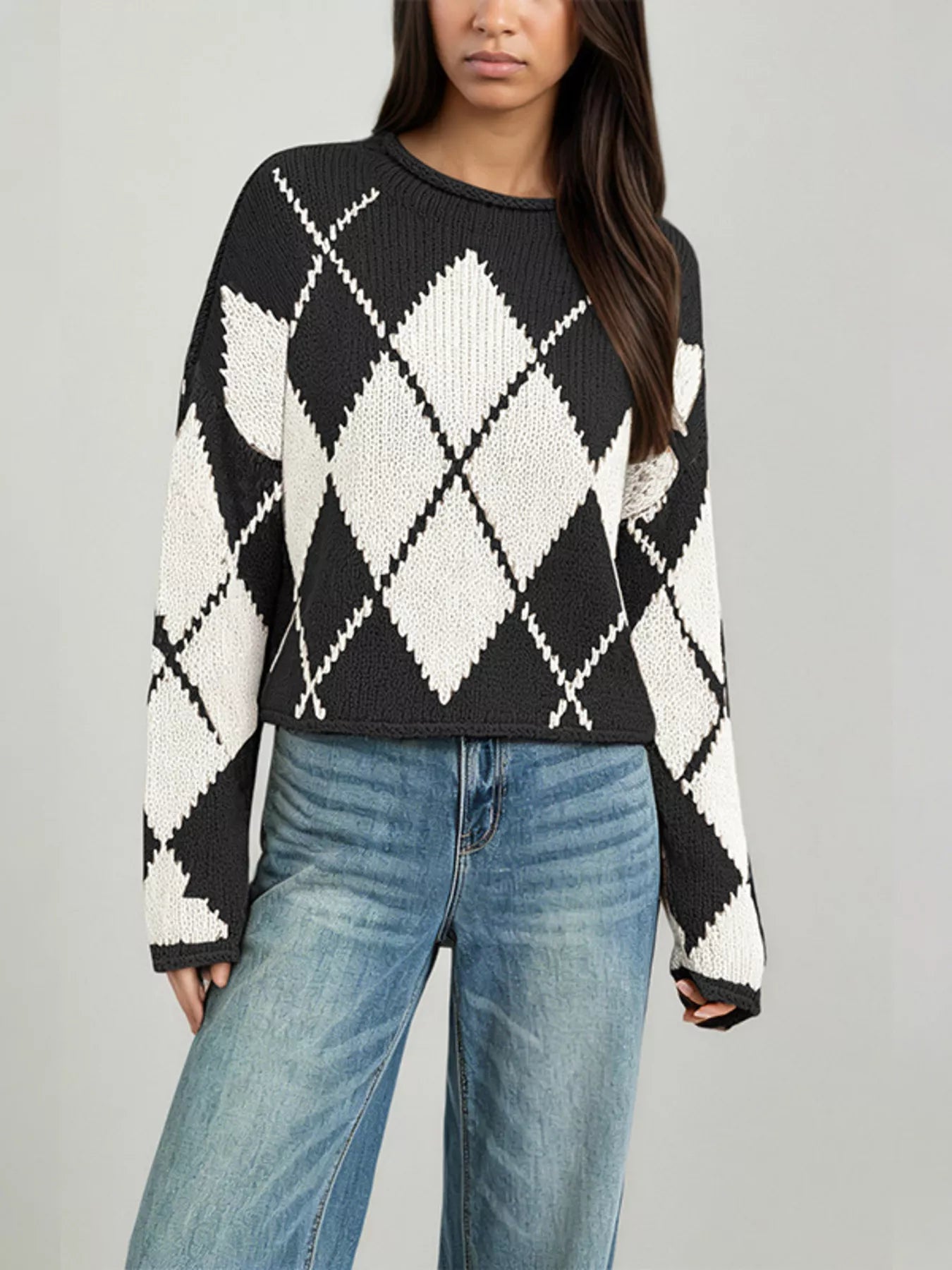 On-model front view of a black and cream argyle knit sweater with dropped shoulders