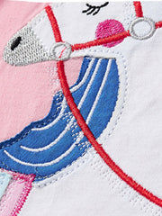 Close detail of embroidered unicorn mane bridle and face on a pink children's ruffle tee