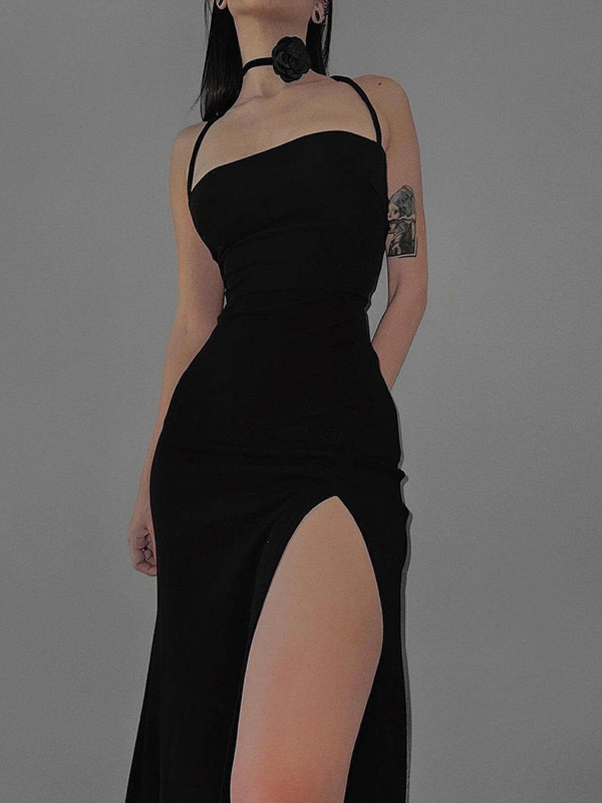 Black halter neck bodycon dress with a high thigh slit worn front facing