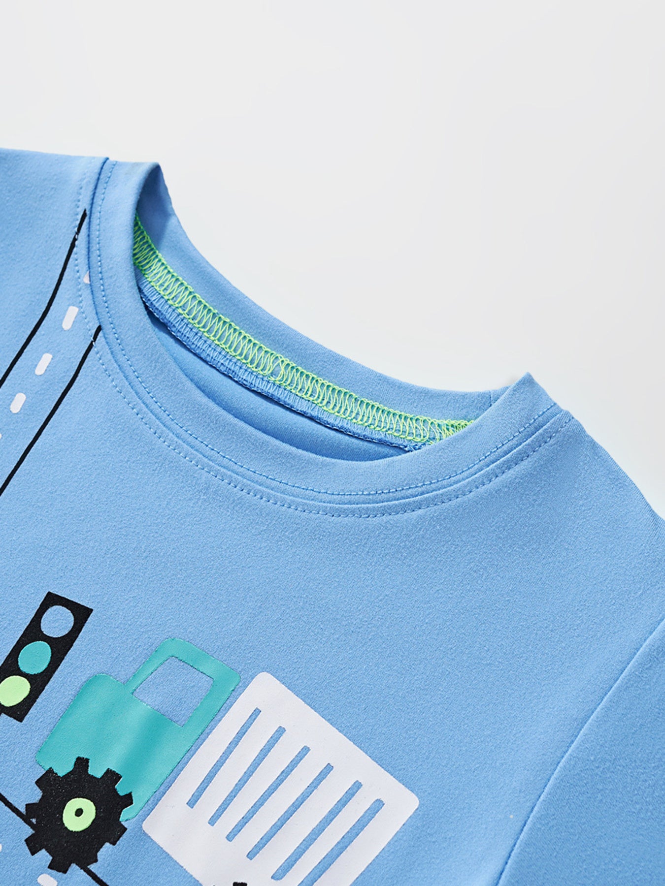 Close view of the round neckline with green inner stitching on the sky blue children's t-shirt