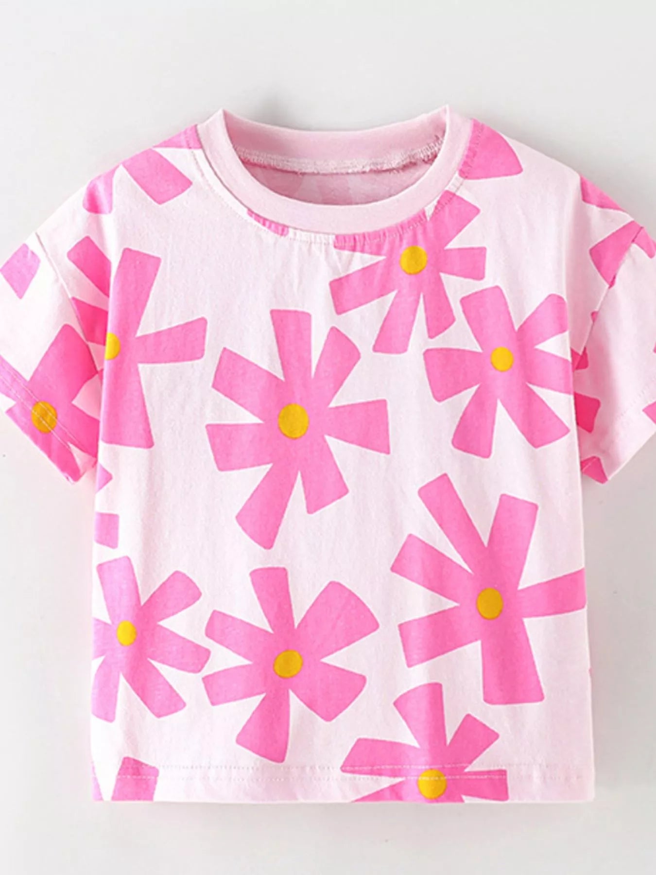 Flat front view of light pink children's t-shirt with bold pink floral print