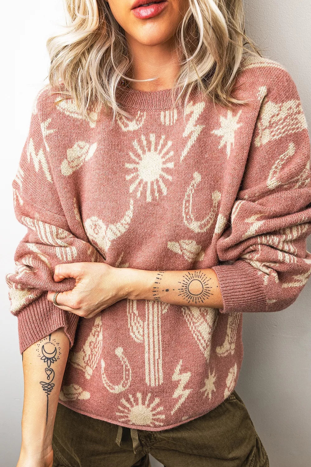 On-model front view of the dusty rose western sweater with arms crossed at the waist
