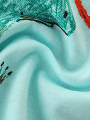 Close-up detail of the soft aqua fabric showing part of a teal dinosaur print