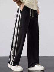 Men's black loose-fit pants with side stripes and a drawstring waist.