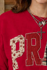 Close detail of scarlet western sweatshirt showing floral and striped patch letters