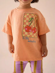 Children's orange round-neck T-shirt featuring a cherry design.