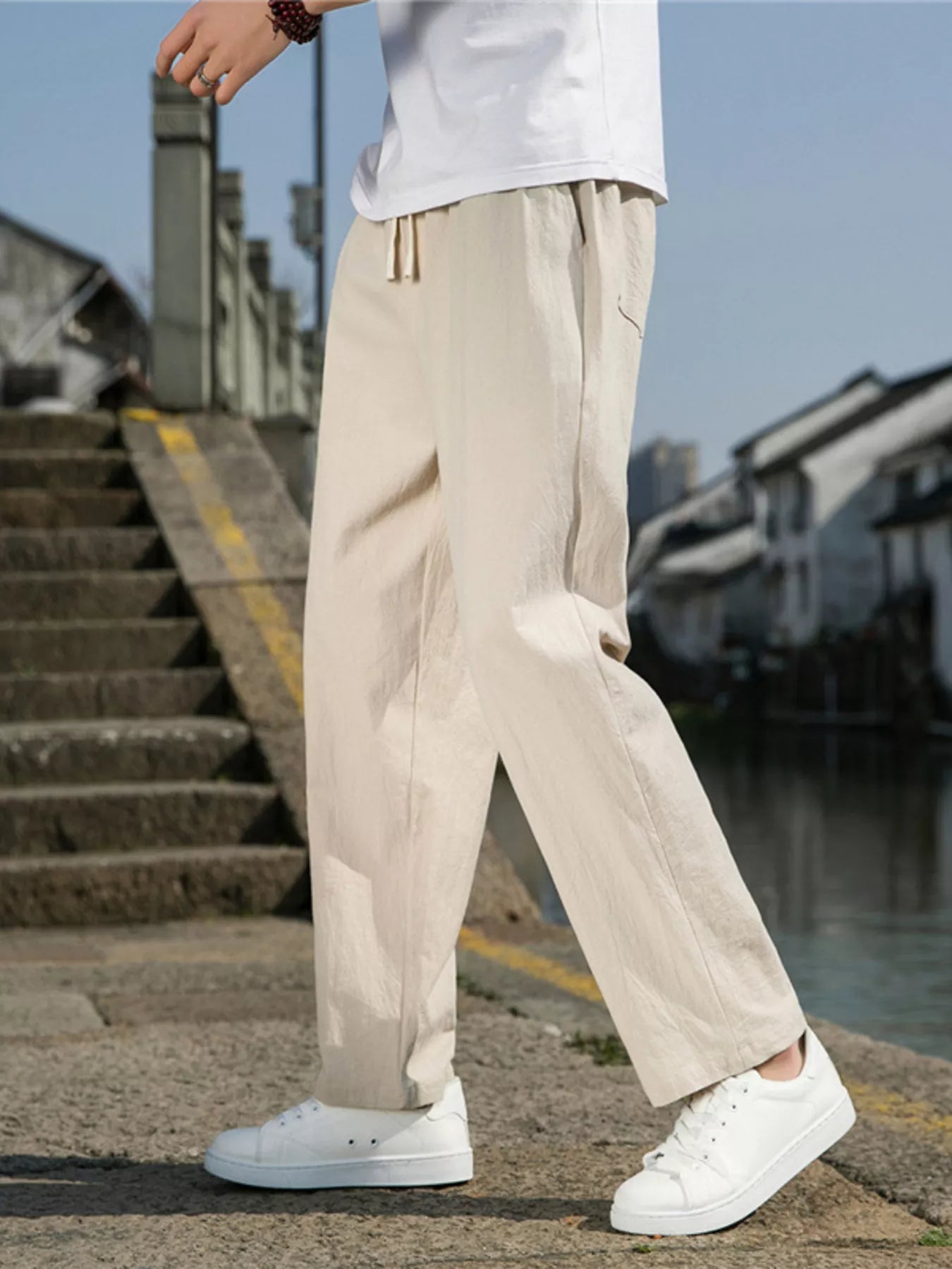 Men's khaki loose-fit casual pants with a drawstring waist and pockets.