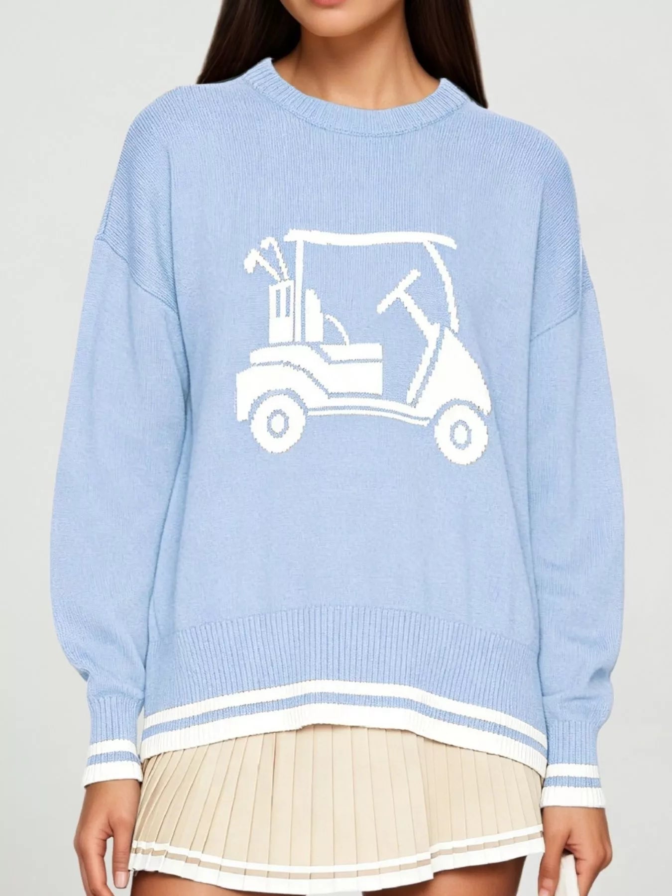 Front view of a light blue dropped shoulder sweater with a white golf cart graphic and striped trim.