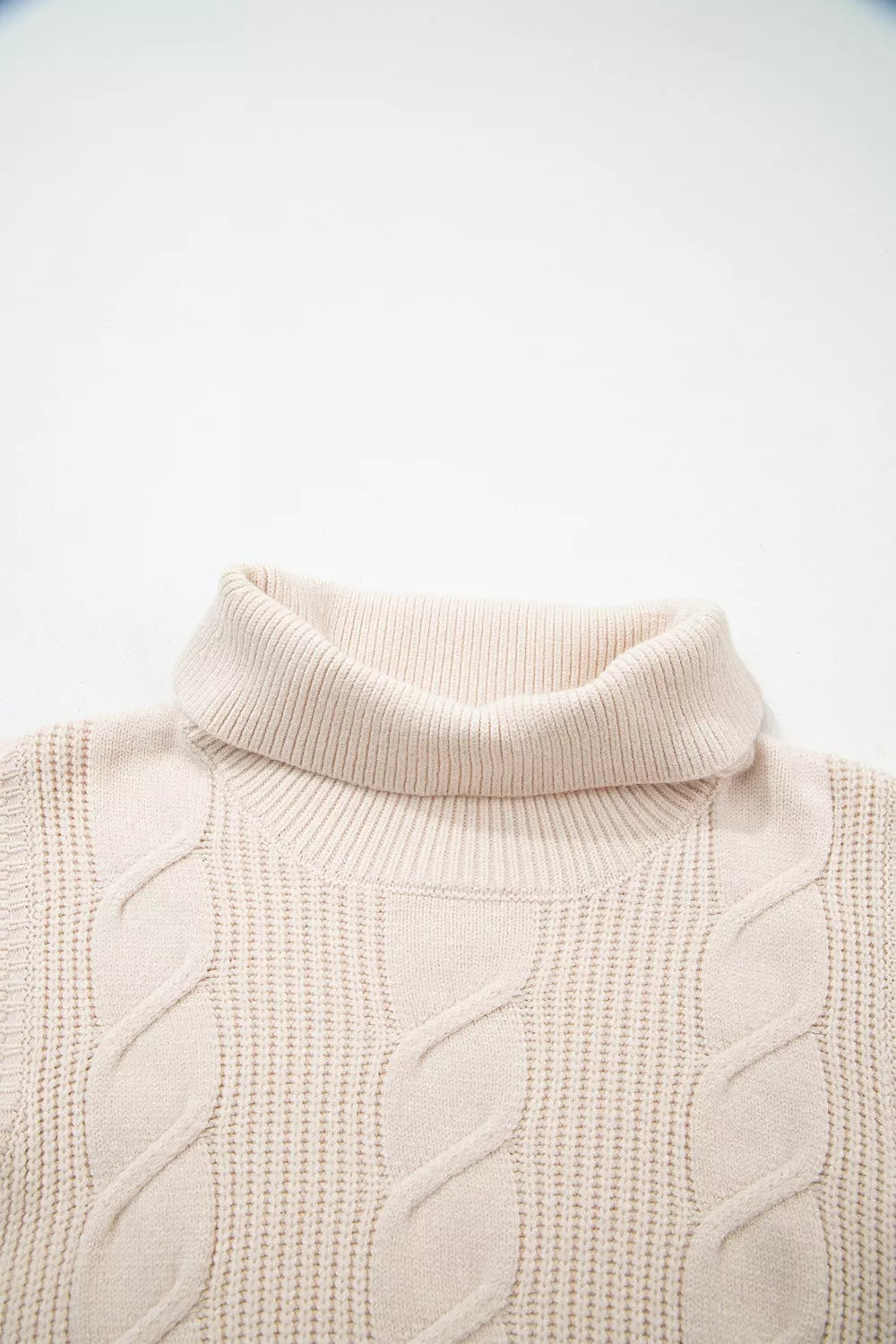 Close-up of the cream cable knit turtleneck sweater back neckline