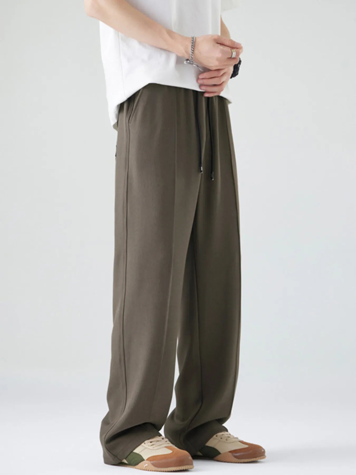 Men's dark brown loose-fit casual pants with a drawstring waist and pockets.