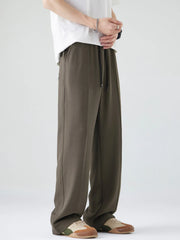 Men's dark brown loose-fit casual pants with a drawstring waist and pockets.