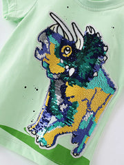 Angled close-up of multicolor sequin dinosaur graphic on light green children's tee