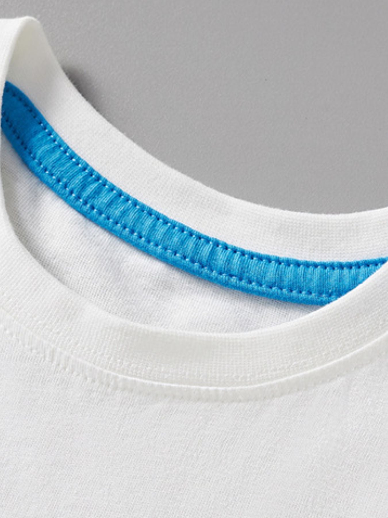Close-up of the white round neckline with a bright blue inner trim on a children's T-shirt