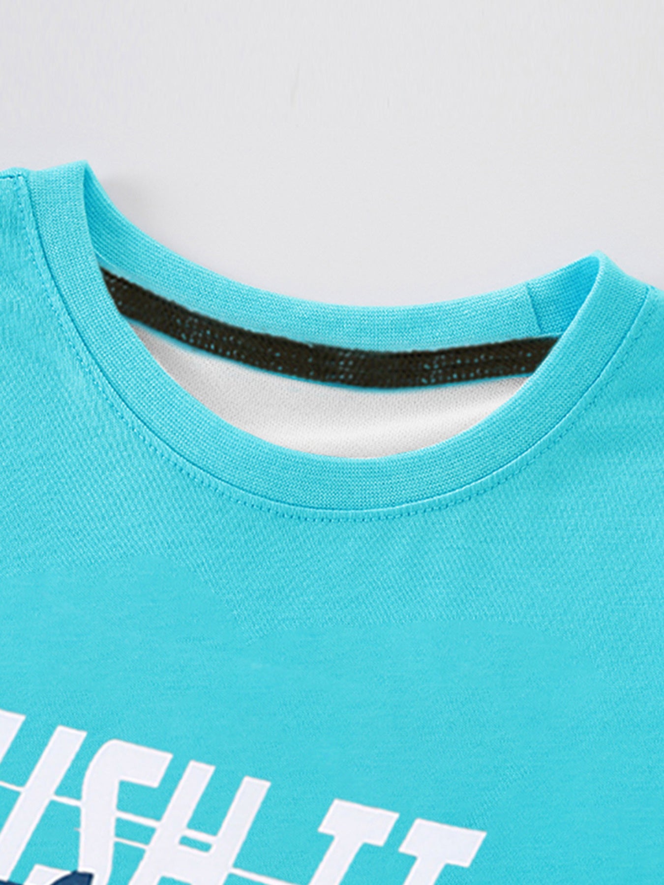Detail view of the ribbed round neckline and inner trim on a children's pastel blue t-shirt