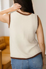 Back view of a beige tie front sweater vest with brown contrast trim