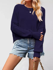 Front view of a dark navy crew neck dropped shoulder sweater with ribbed cuffs worn with denim shorts.