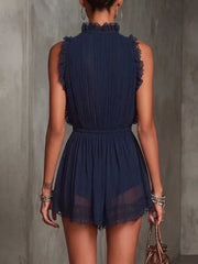 Back view of navy blue sleeveless mini dress with pleated back and lace hem