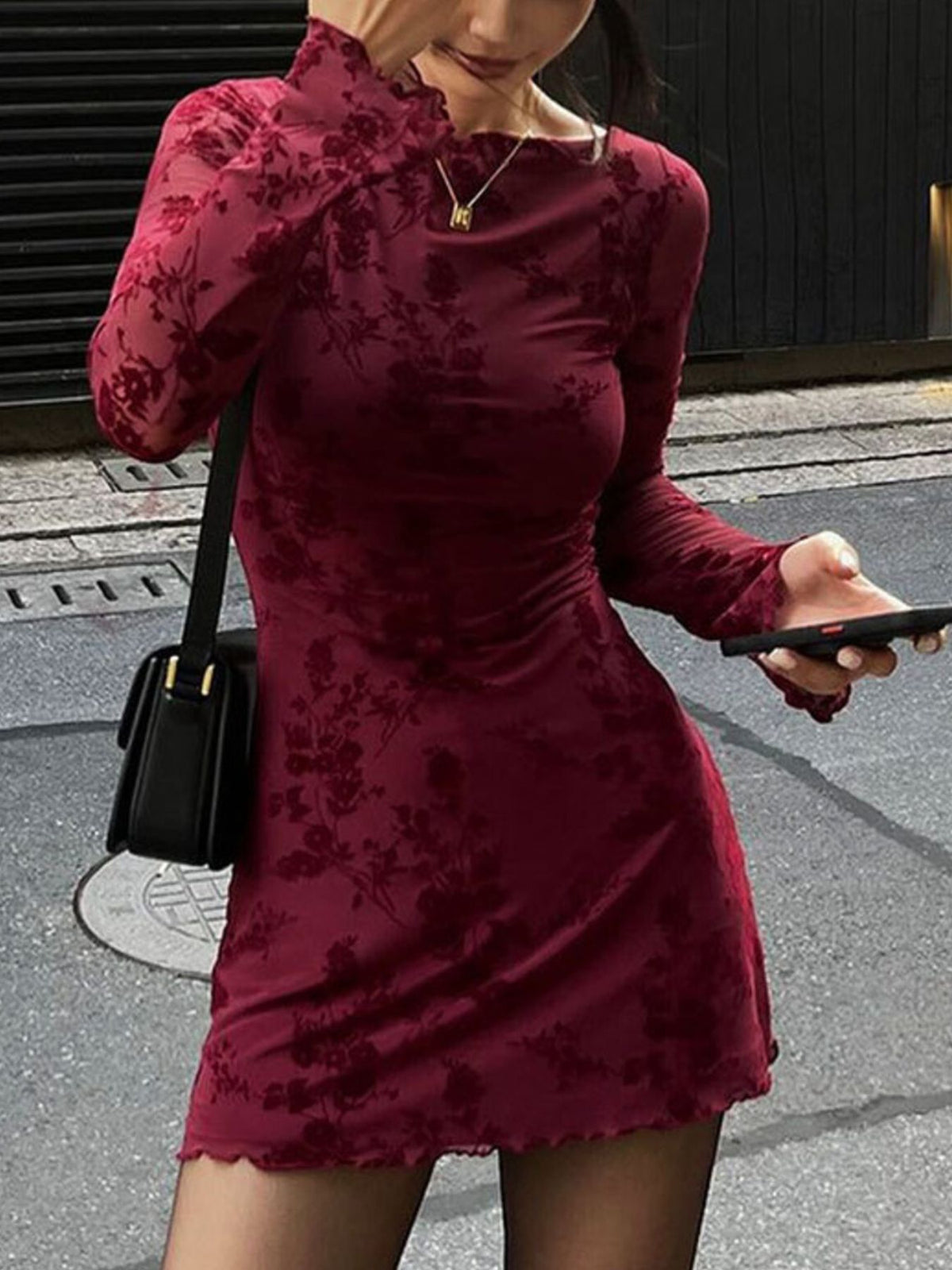 Burgundy floral long sleeve bodycon mini dress with sheer sleeves, front view outdoors