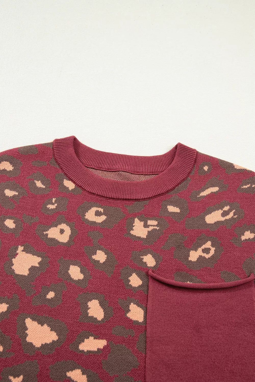 Close-up of the deep red leopard print knit top neckline and chest pocket