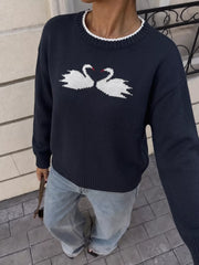 Front view of a navy knit sweater with white swans, red beaks, and ribbed hem