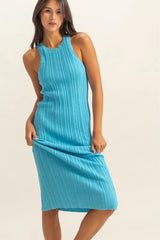 Three quarter front view of bright blue ribbed knit bodycon dress with model holding the skirt