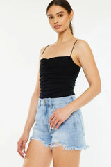 Women's distressed high-waisted denim shorts with washed detailing, pockets, and raw hems.