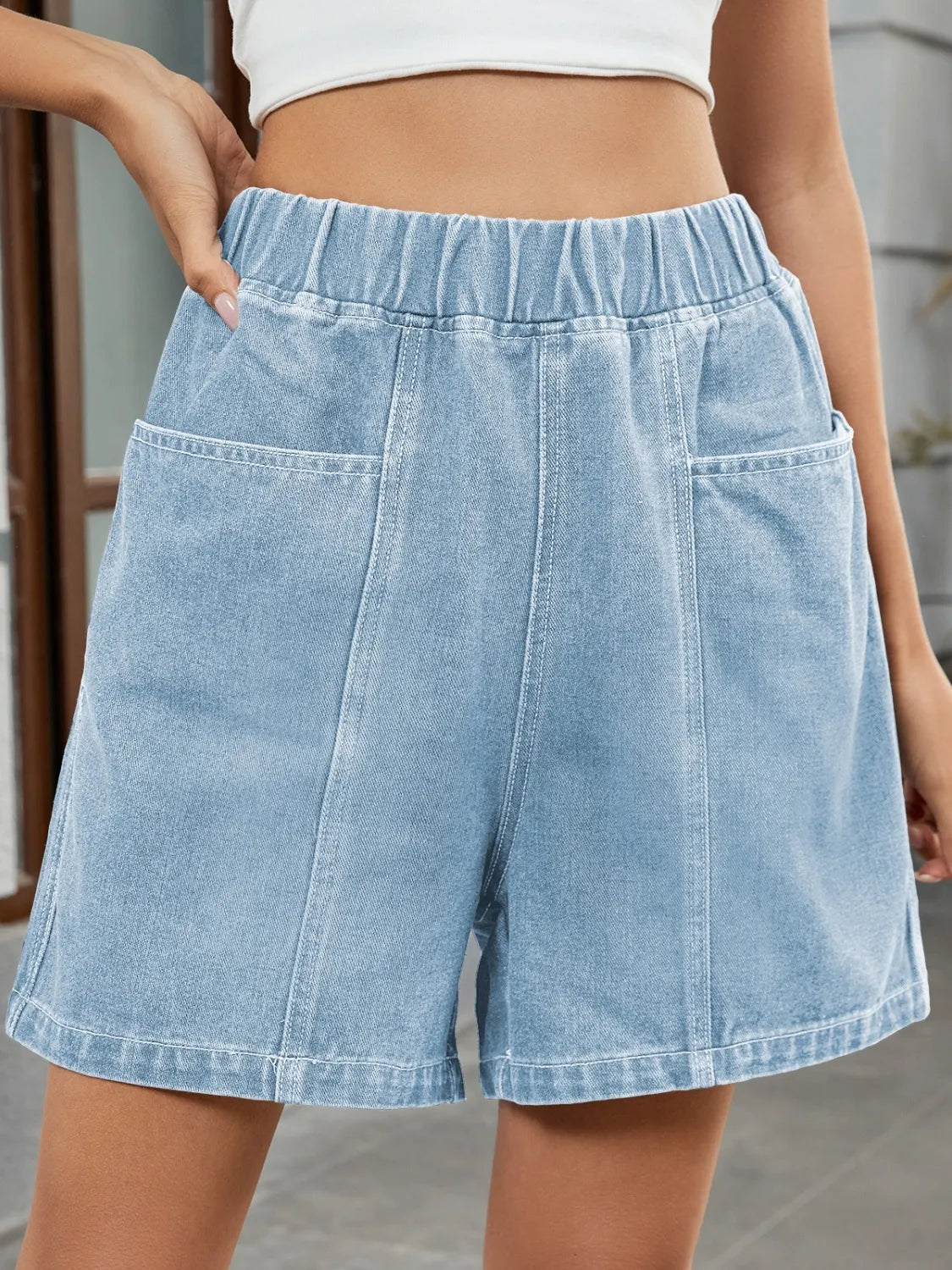 Women's denim shorts with an elastic waistband and pockets.