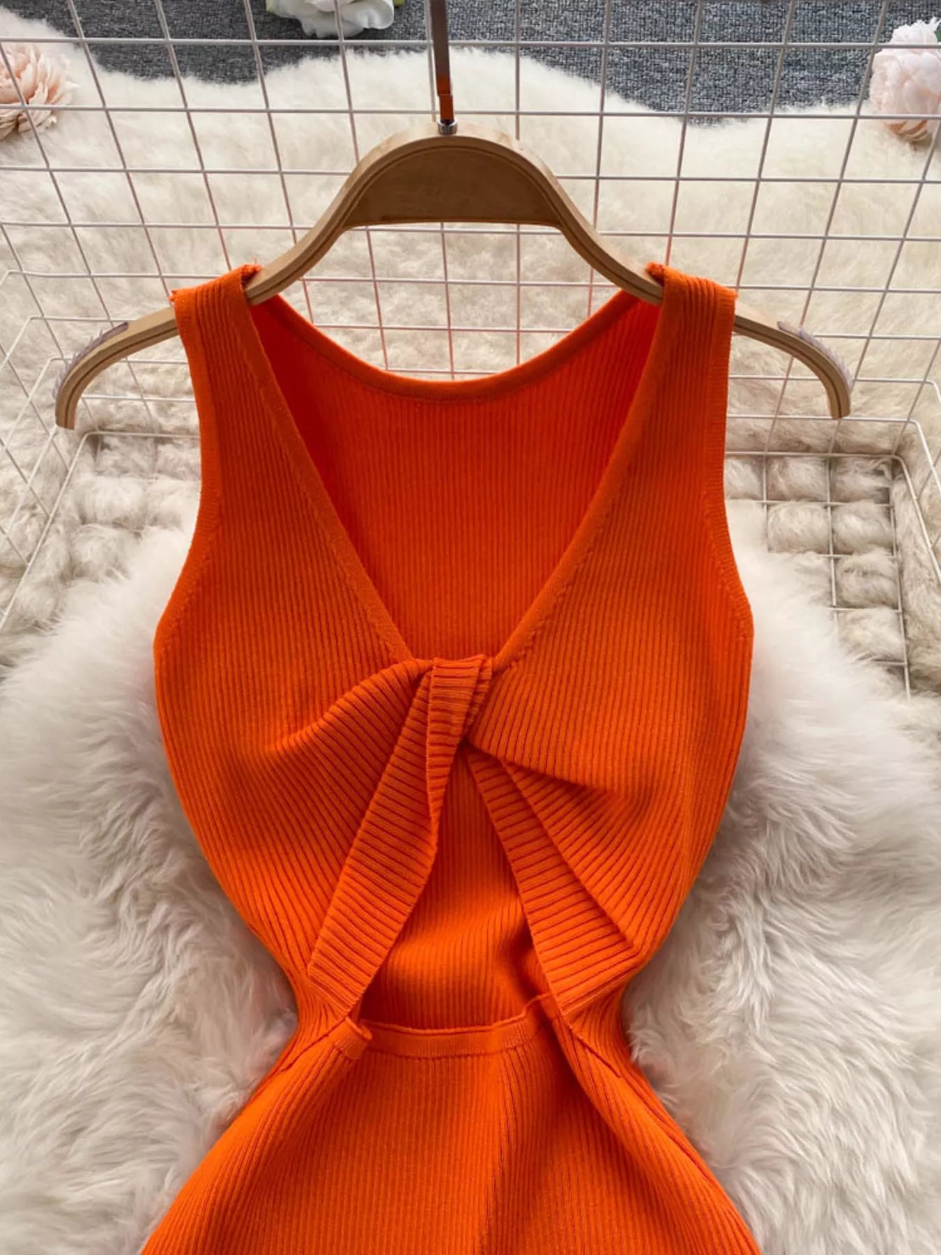 Close back view of orange ribbed knit dress showing knotted open back detail