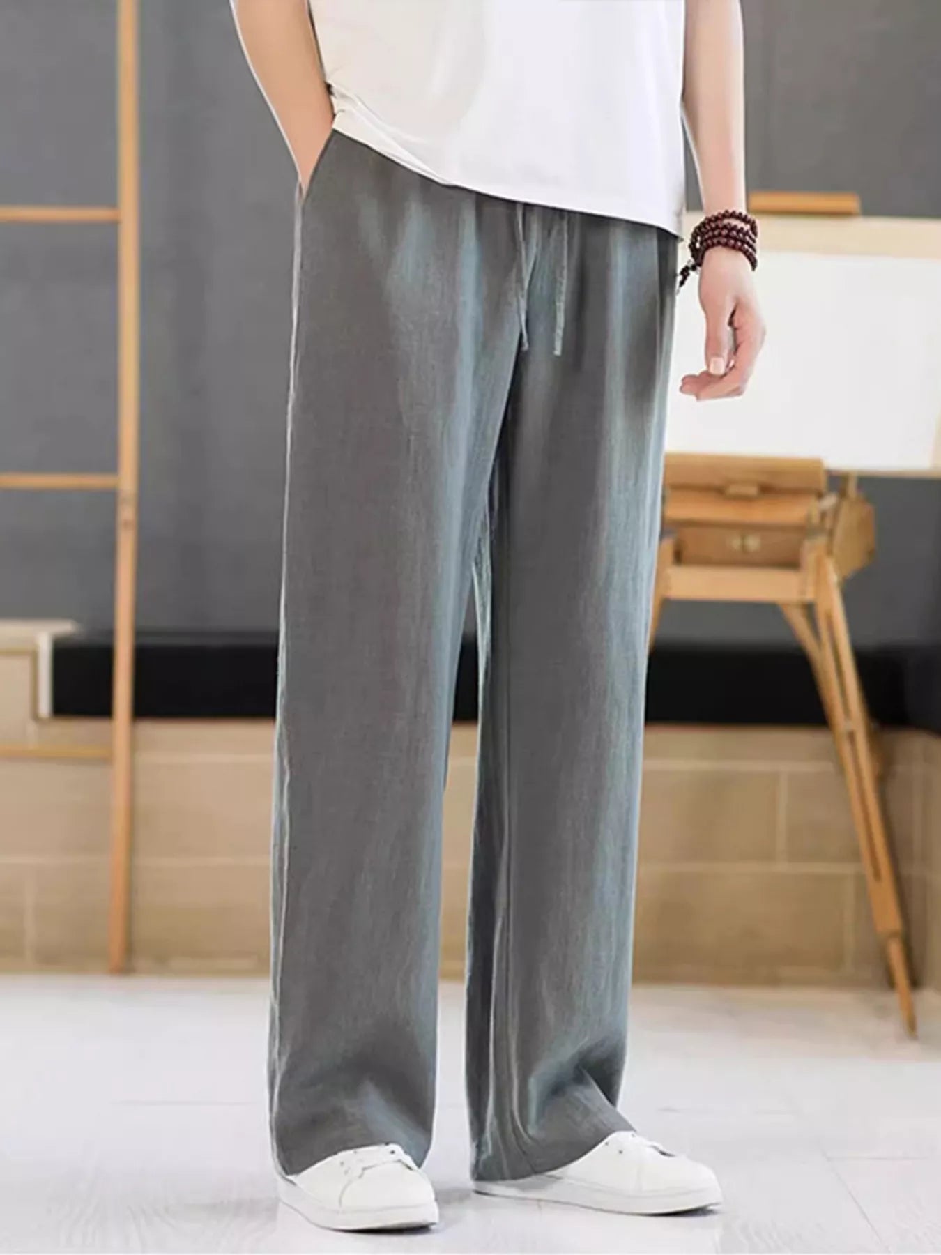 Men's dark gray casual pants with a drawstring waist and pockets.