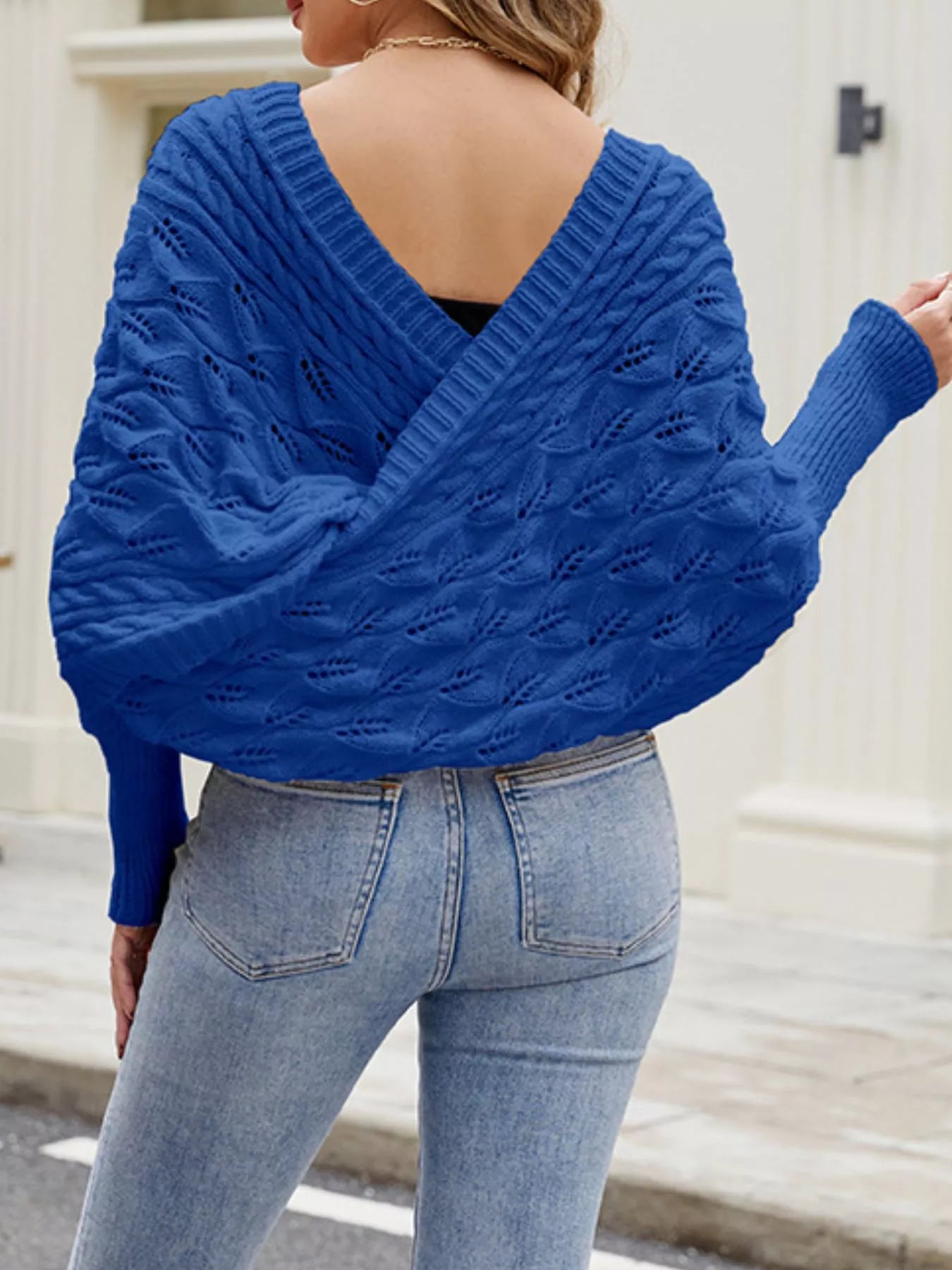 Back view of blue batwing sweater with deep V back and cable knit.