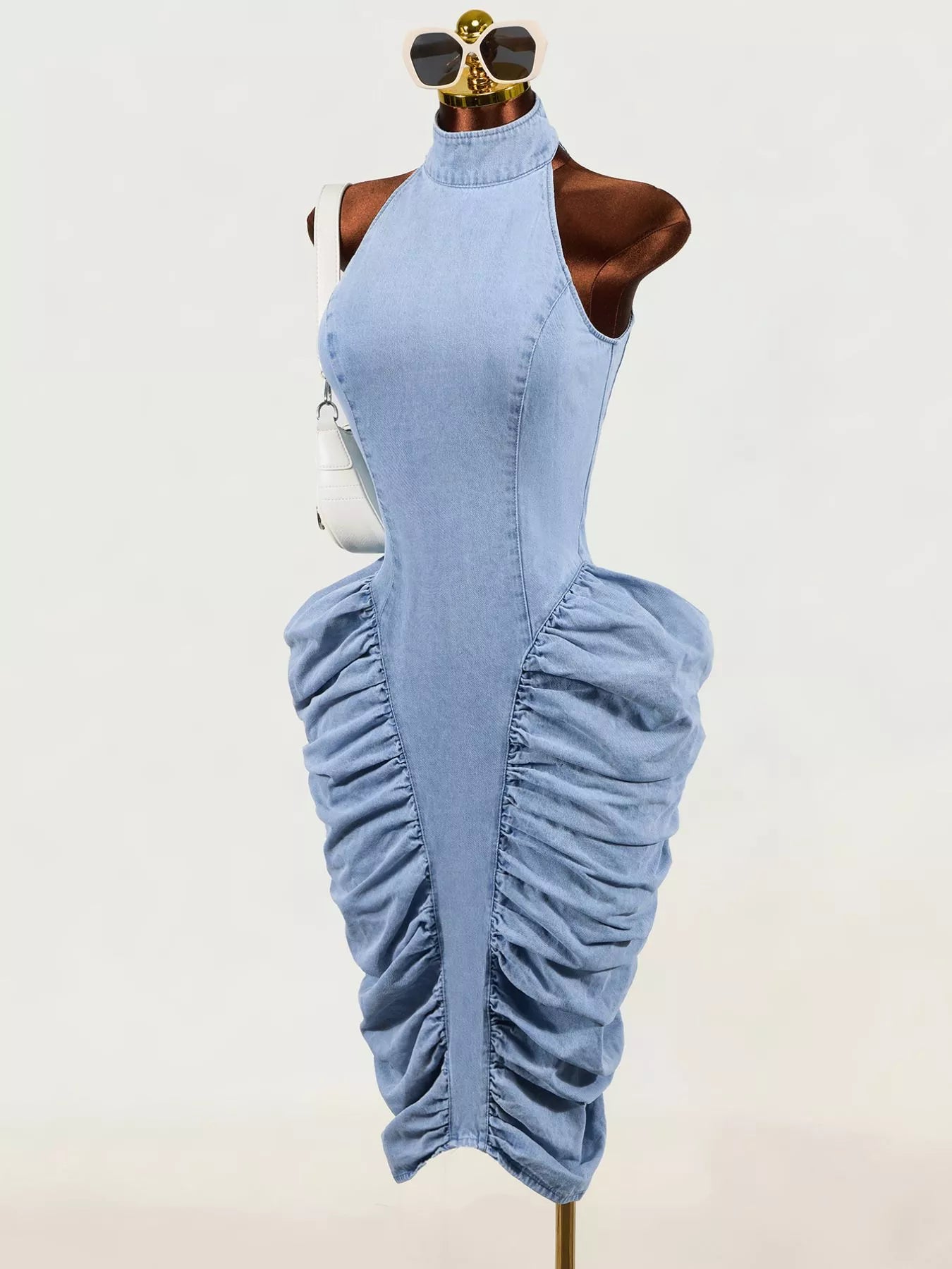 Light blue sleeveless mock neck ruched bodycon denim dress on mannequin, three quarter front view