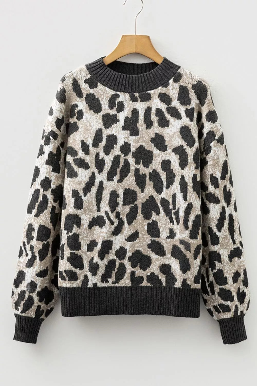 Flat lay front view of the gray and black leopard print baggy sweater on a hanger.