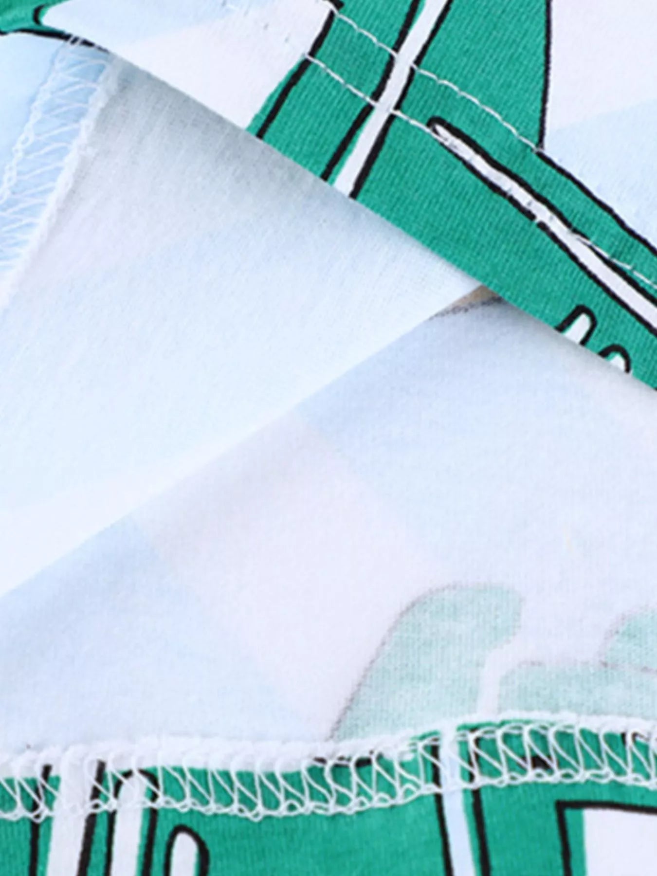 Close-up of the hem stitching detail and green vehicle print on a children's T-shirt