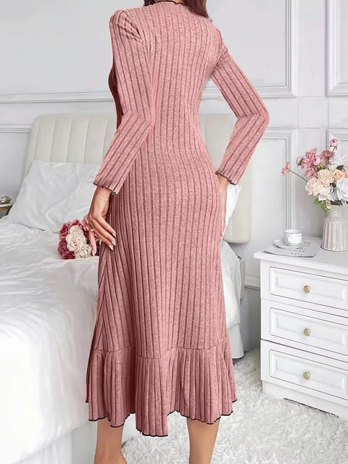 Back view of dusty pink ribbed knit bodycon dress with ruffle hem indoors