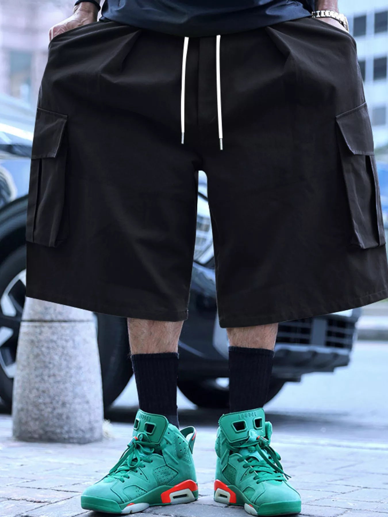 Men's black cargo shorts with a drawstring waist and pockets.