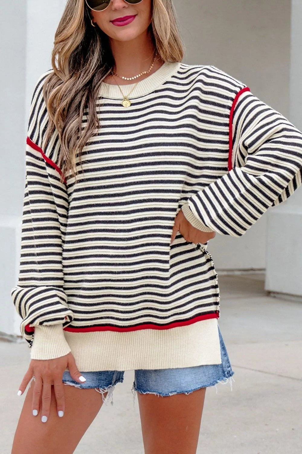 On-model front view of the striped oversized sweater with red shoulder seams and ribbed trim