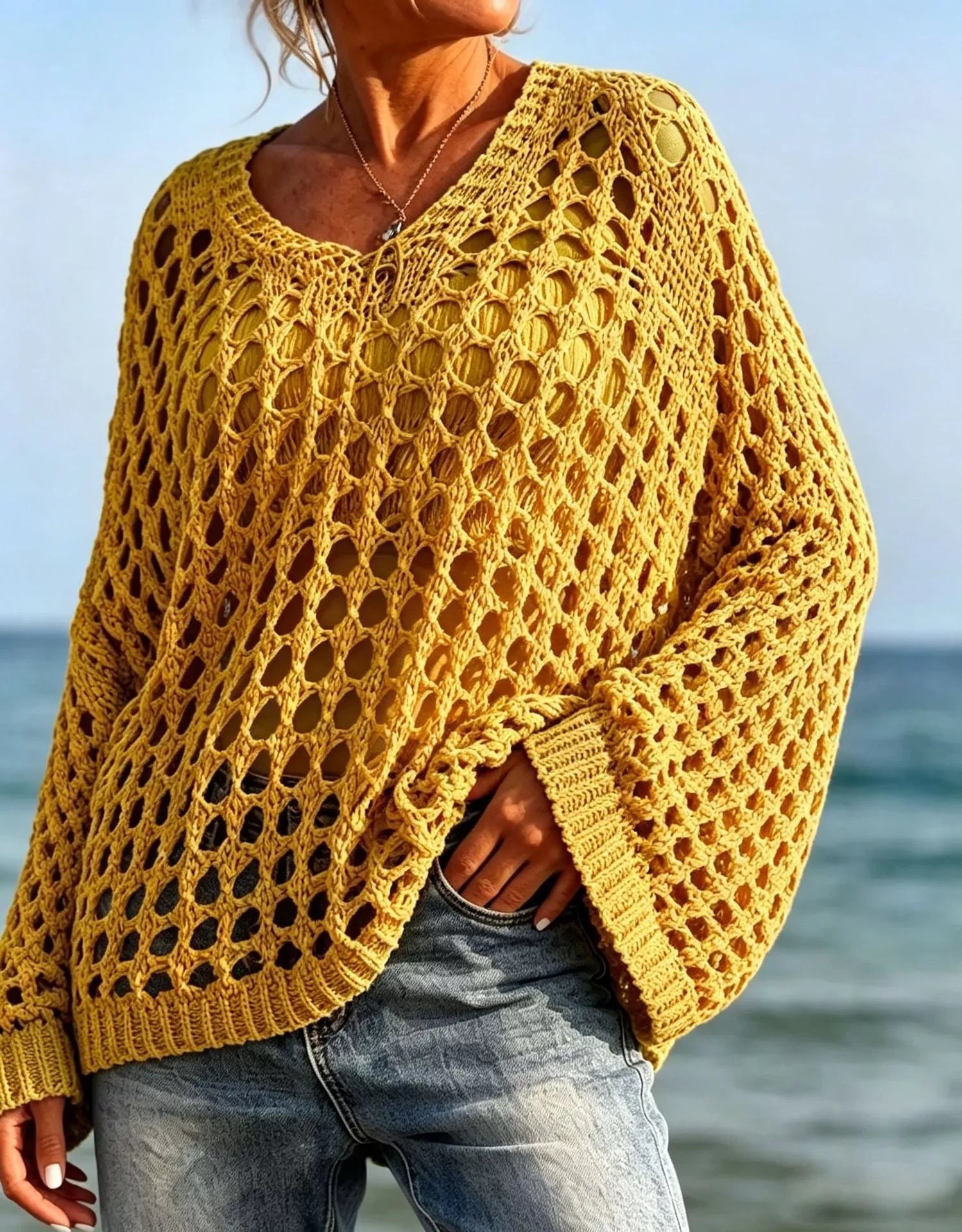 Front view of mustard yellow openwork crochet knit cover up with V neck at the beach.