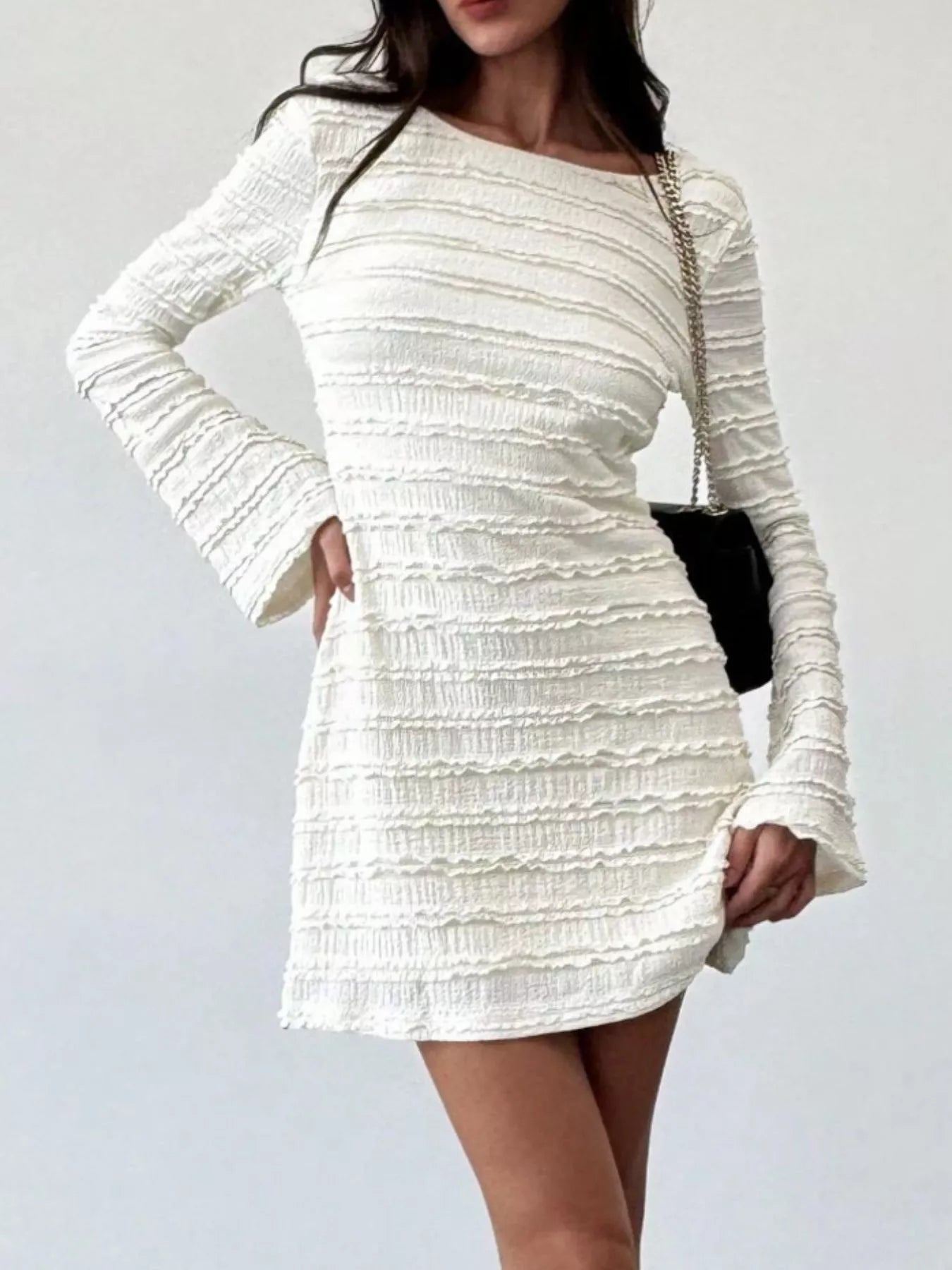 Model wearing pale apricot textured flare sleeve bodycon mini dress, front view with hand on hip