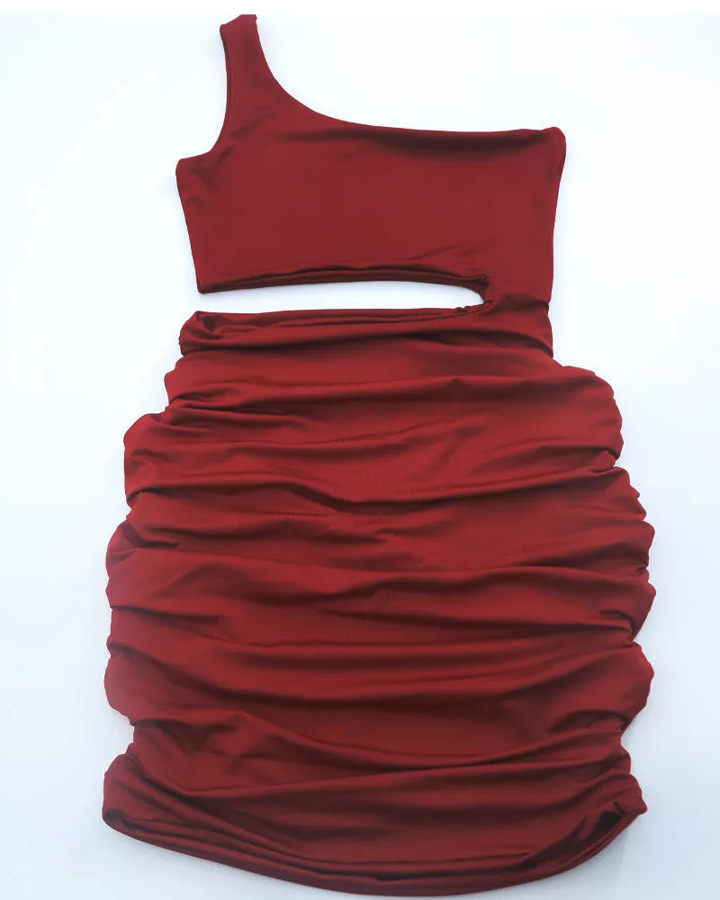 Flat lay of burgundy one shoulder cutout ruched bodycon mini dress with strap on the left