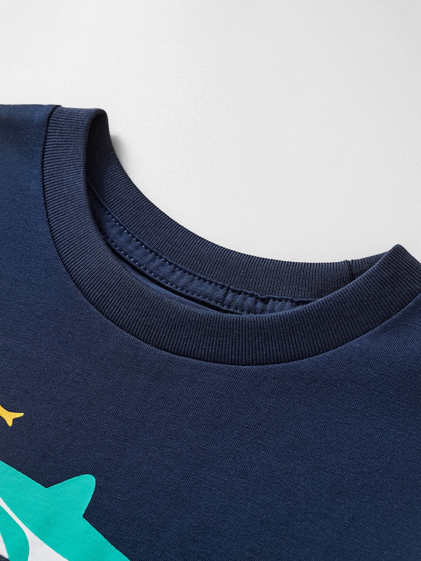 Close view of the ribbed crew neckline on the dark navy children's t-shirt