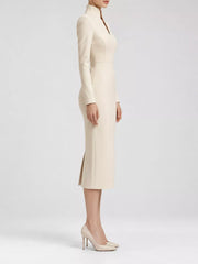 Pale apricot stand collar long sleeve midi dress in side profile showing hem slit