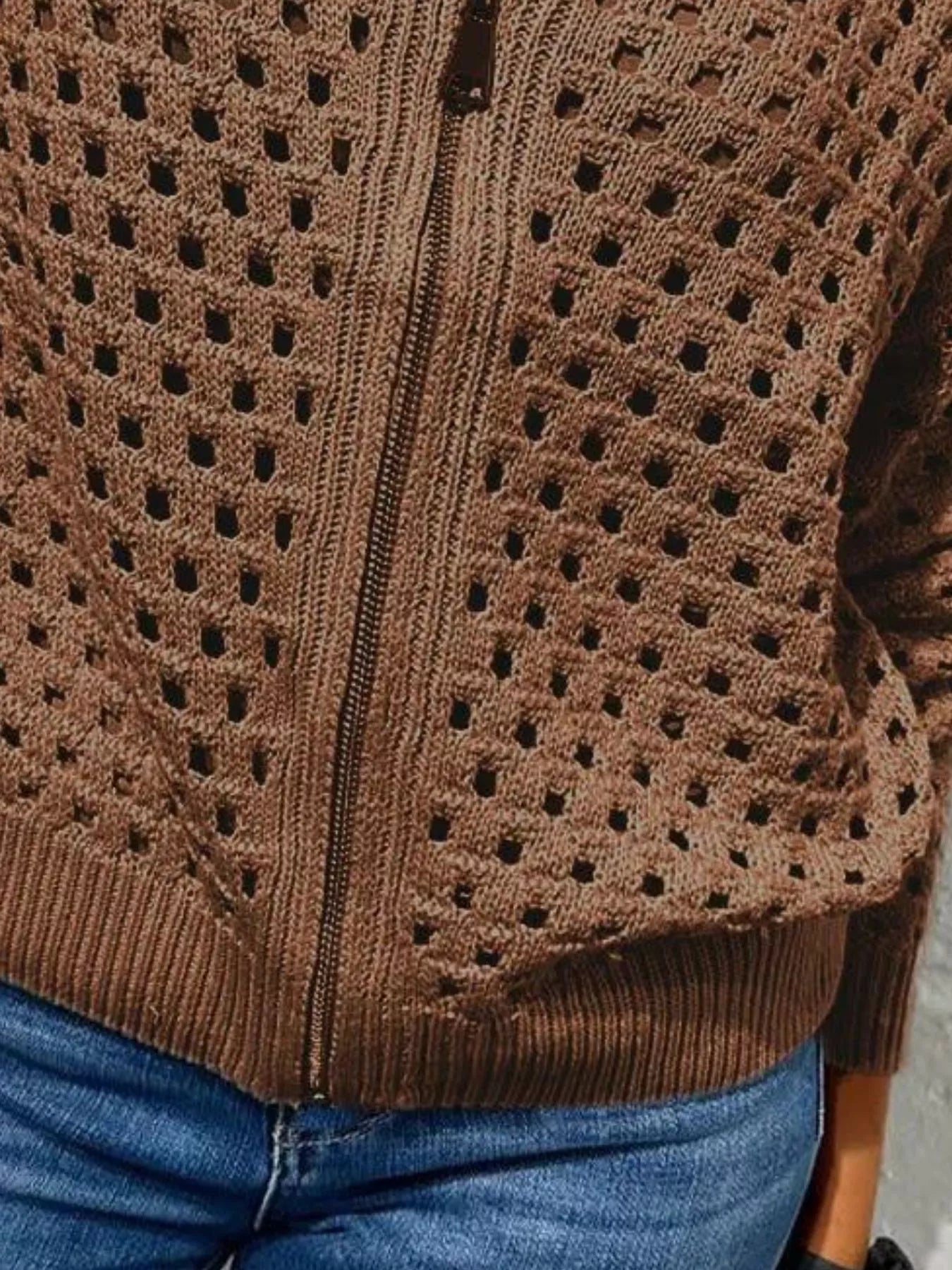 Close up of the dark brown crochet cardigan lower zip and ribbed hem